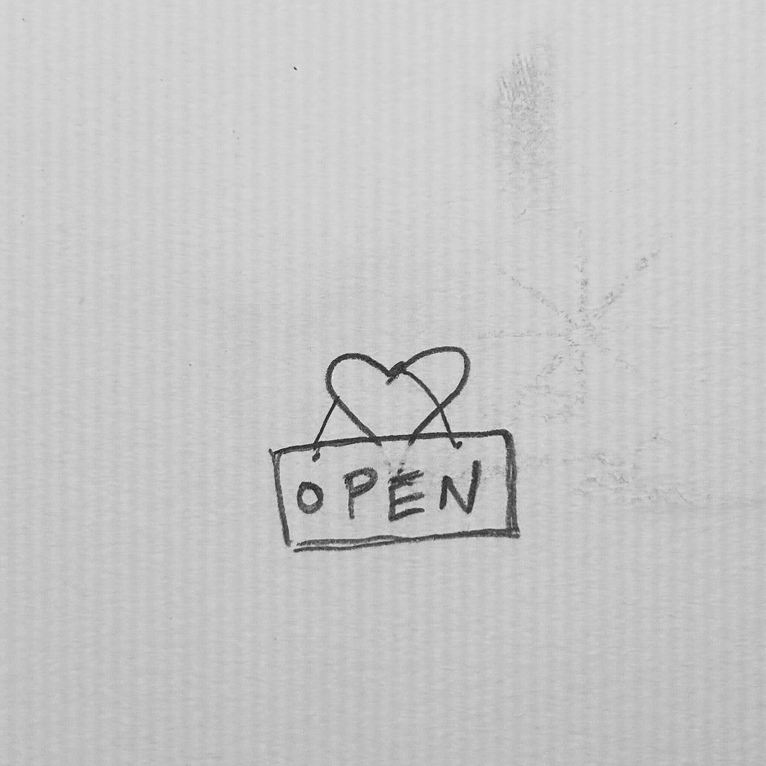 A heart with an OPEN sign hanging from it